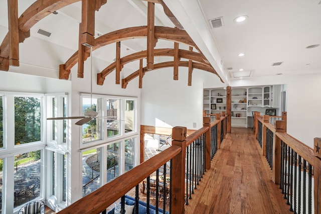 hallway featuring beamed ceiling, light hardwood / wood-style flooring, and high vaulted ceiling