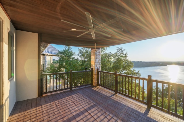 wooden terrace with a water view and ceiling fan