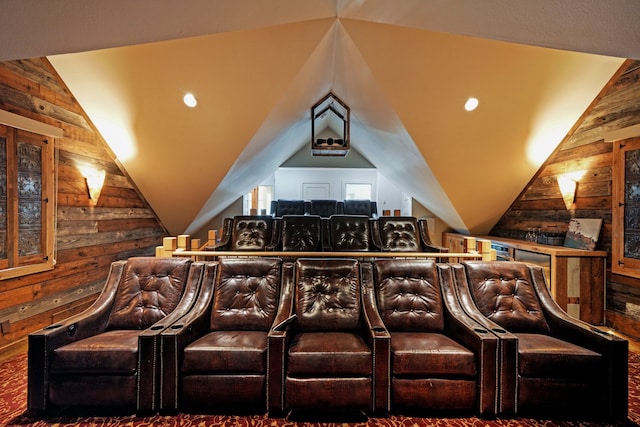 carpeted cinema room with lofted ceiling and wood walls