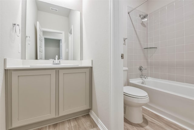 bathroom featuring vanity, visible vents, toilet, and wood finished floors