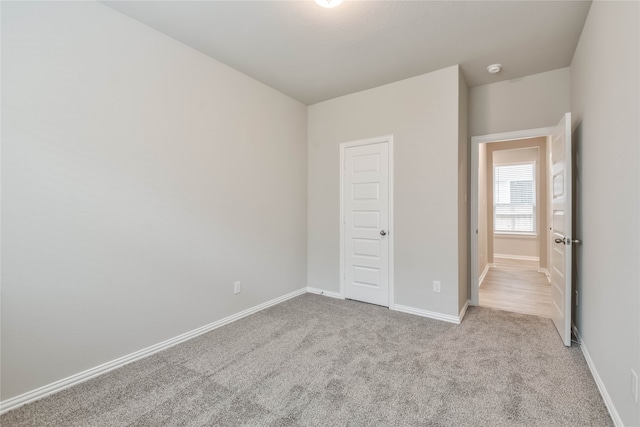 unfurnished bedroom with a closet and light carpet