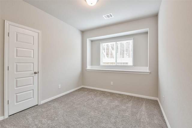 carpeted spare room featuring visible vents and baseboards