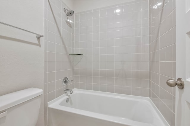 bathroom with tiled shower / bath and toilet