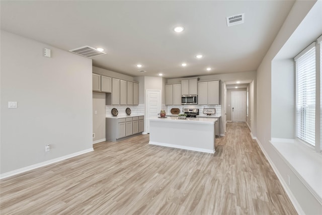 kitchen with stainless steel appliances, visible vents, decorative backsplash, and gray cabinets