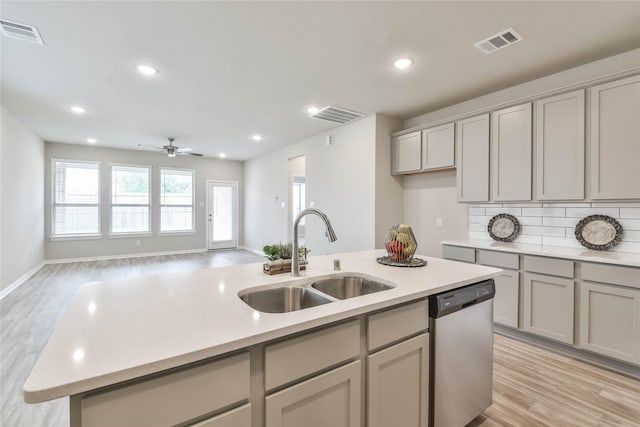 kitchen with gray cabinetry, dishwasher, visible vents, and a sink