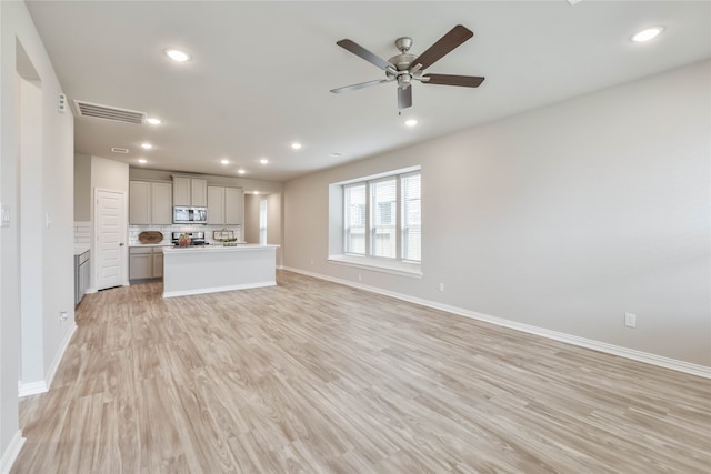 unfurnished living room with light hardwood / wood-style floors and ceiling fan