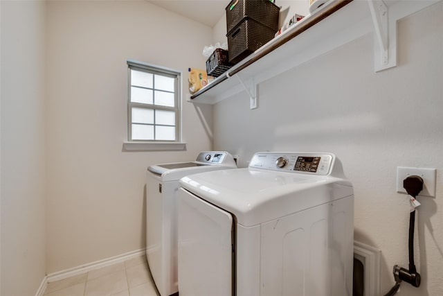 laundry room featuring washing machine and clothes dryer and light tile floors