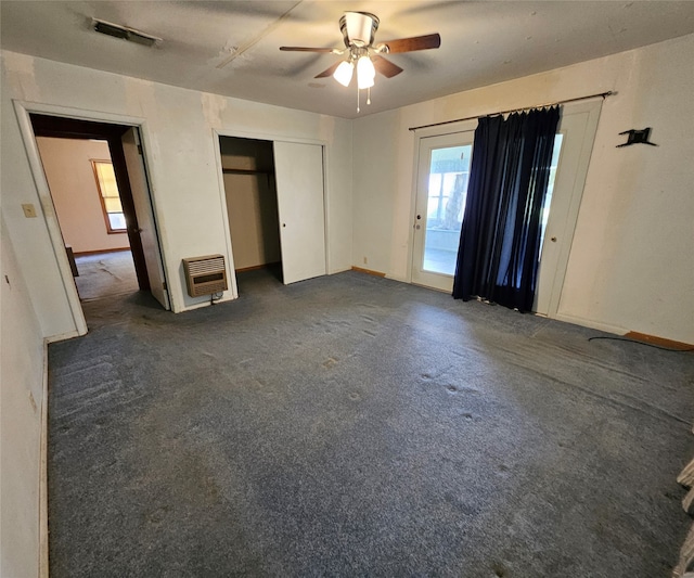 unfurnished bedroom with carpet, heating unit, and ceiling fan