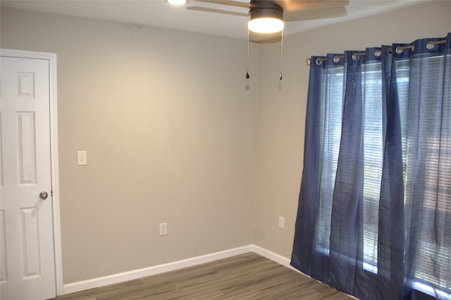 spare room featuring dark hardwood / wood-style flooring and ceiling fan