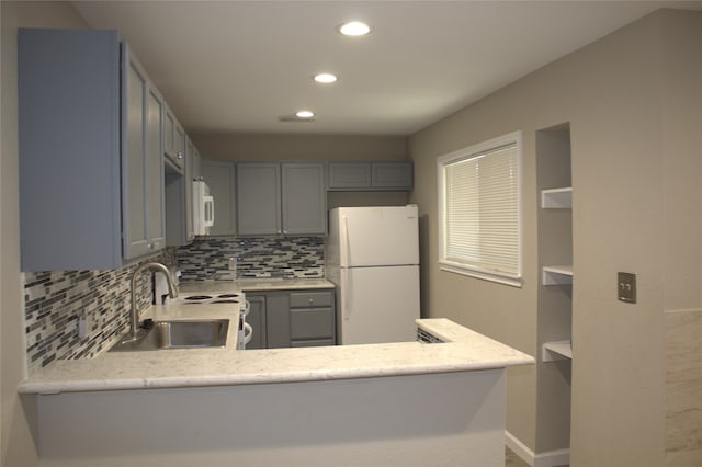 kitchen featuring white appliances, sink, backsplash, and gray cabinetry