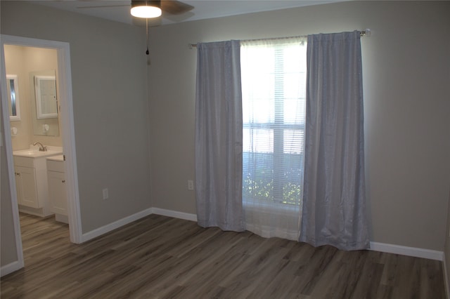 interior space featuring sink, connected bathroom, dark wood-type flooring, and ceiling fan