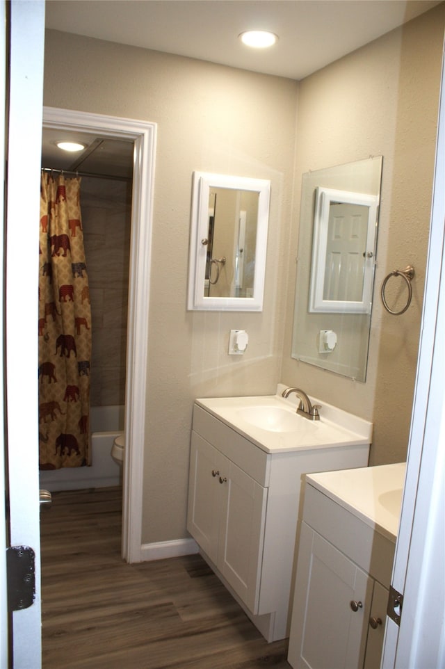 bathroom with hardwood / wood-style flooring, toilet, and large vanity