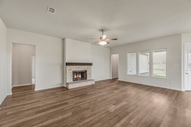 unfurnished living room featuring ceiling fan and dark wood-type flooring