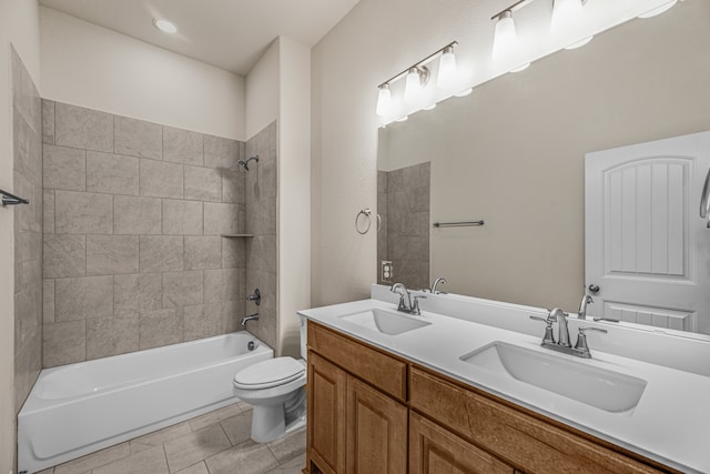 full bathroom featuring tile patterned flooring, tiled shower / bath combo, vanity, and toilet