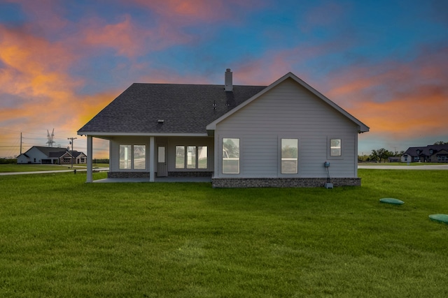 back house at dusk with a yard