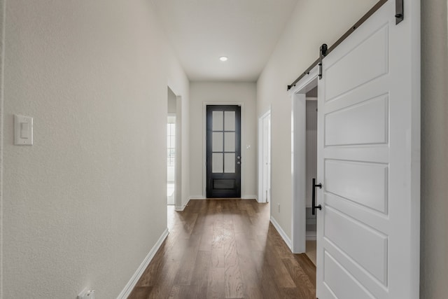 doorway to outside featuring a barn door and dark hardwood / wood-style flooring