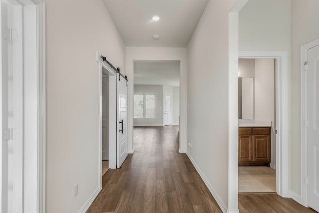 hall featuring a barn door and dark hardwood / wood-style flooring