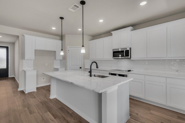 kitchen featuring tasteful backsplash, white cabinets, pendant lighting, and light hardwood / wood-style floors