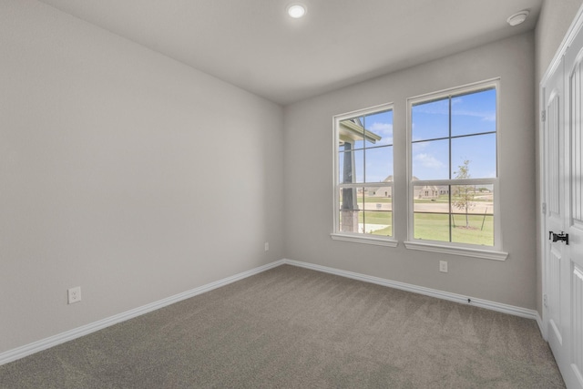 carpeted spare room featuring baseboards