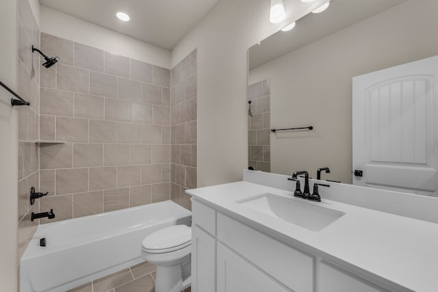 full bathroom featuring toilet, tiled shower / bath combo, vanity, and tile patterned floors