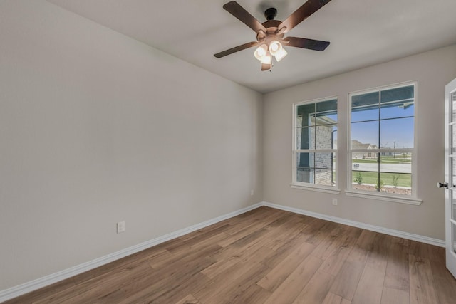 spare room with a ceiling fan, baseboards, and wood finished floors