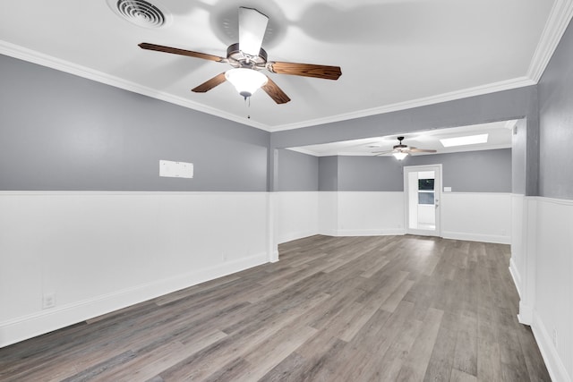 spare room featuring ceiling fan, hardwood / wood-style floors, and ornamental molding