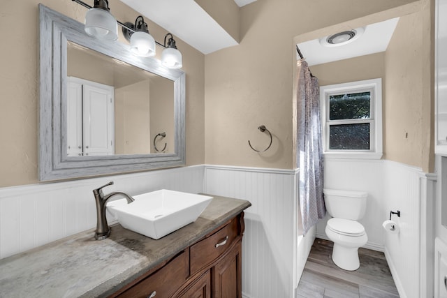 bathroom with hardwood / wood-style floors, vanity, and toilet