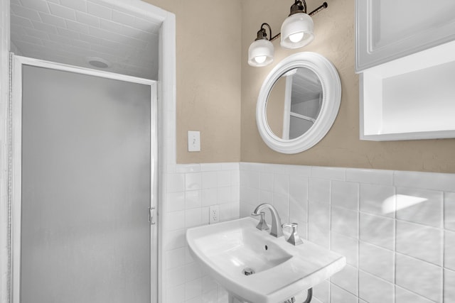 bathroom featuring tile walls, walk in shower, sink, and tasteful backsplash