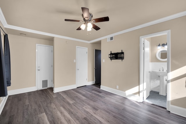 unfurnished bedroom featuring ornamental molding, dark hardwood / wood-style flooring, ensuite bath, sink, and ceiling fan