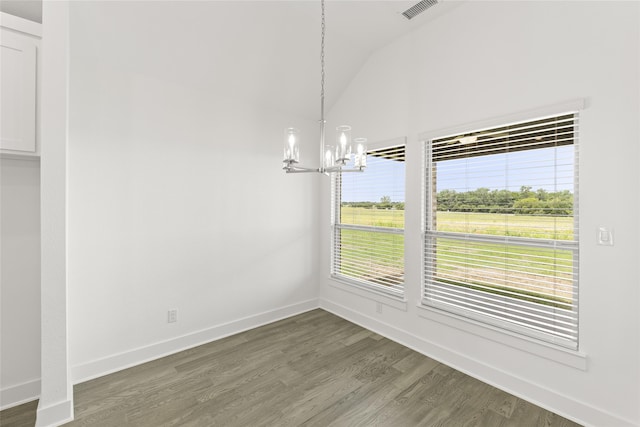 unfurnished dining area with a chandelier, lofted ceiling, dark hardwood / wood-style flooring, and a wealth of natural light