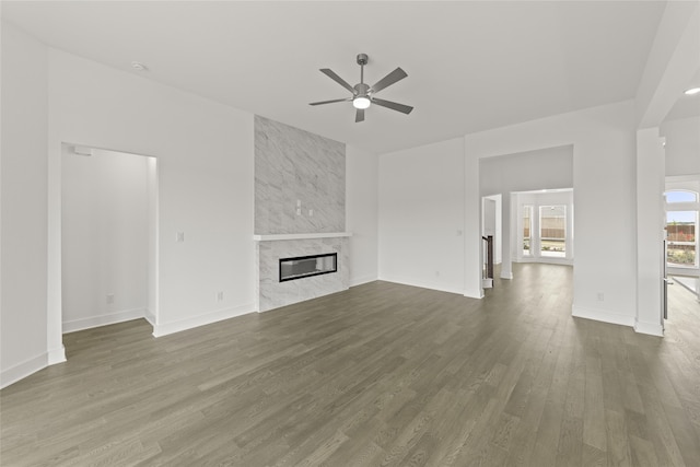 unfurnished living room with wood-type flooring, ceiling fan, and a high end fireplace