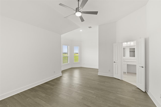 empty room with ceiling fan, high vaulted ceiling, and dark wood-type flooring