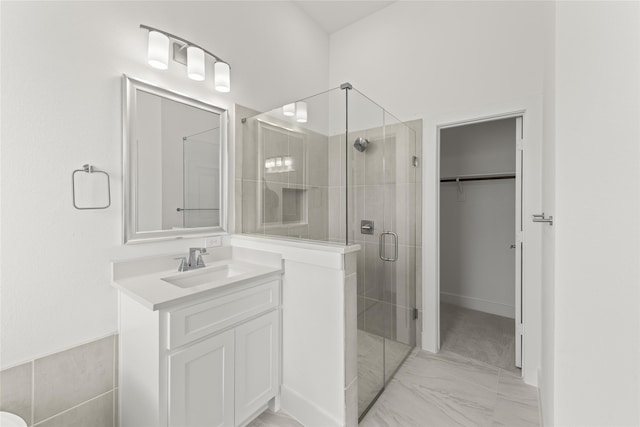 bathroom featuring a shower with shower door, vanity, and tile patterned floors