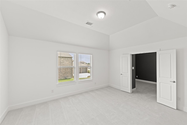 unfurnished room featuring light carpet and lofted ceiling