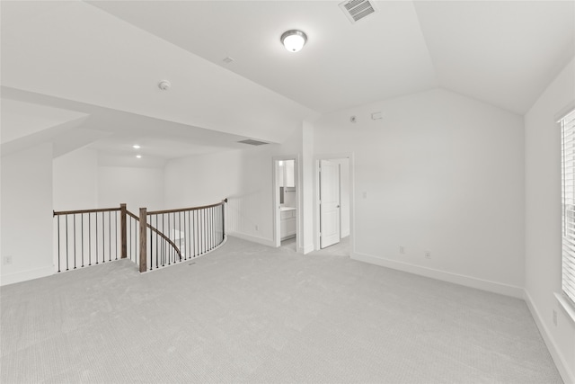 empty room featuring lofted ceiling and light carpet