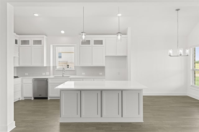 kitchen with a kitchen island, pendant lighting, sink, white cabinets, and decorative backsplash