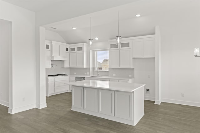 kitchen featuring sink, white cabinetry, a center island, hanging light fixtures, and dark hardwood / wood-style flooring