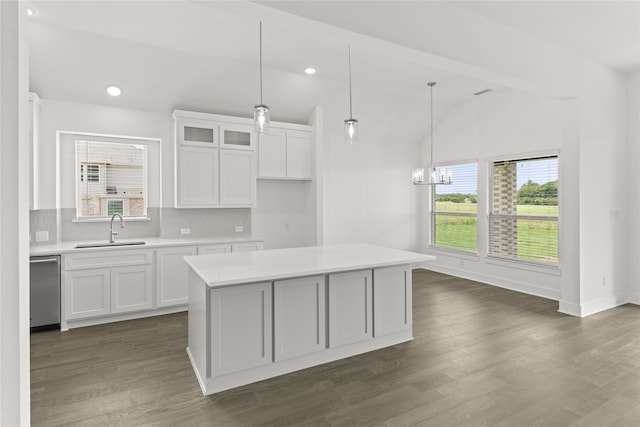 kitchen featuring pendant lighting, white cabinetry, sink, a center island, and stainless steel dishwasher