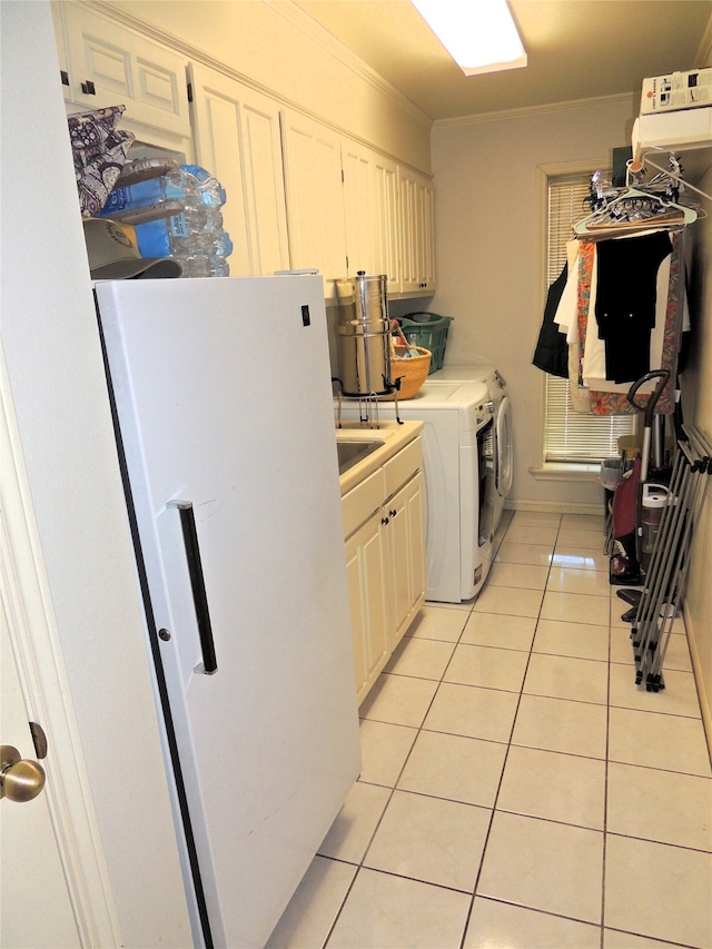 washroom featuring washing machine and dryer, light tile flooring, and cabinets