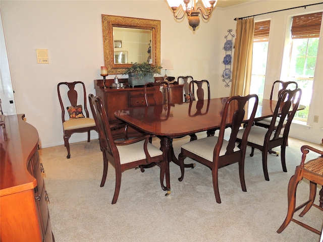 dining room with light carpet and a notable chandelier