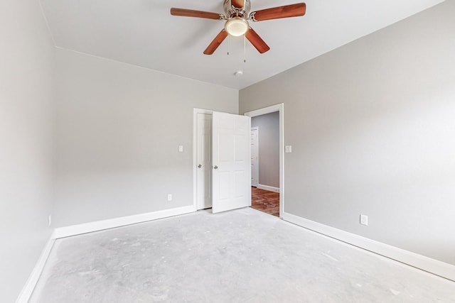 unfurnished room with ceiling fan and concrete floors