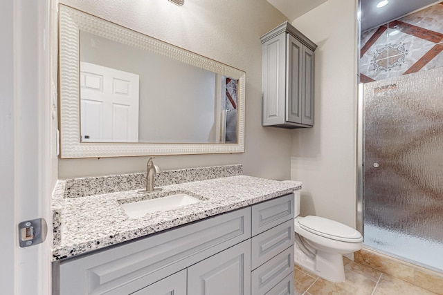 bathroom with toilet, a shower with door, tile patterned flooring, and vanity