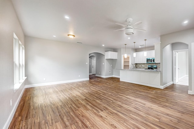 unfurnished living room with light hardwood / wood-style flooring and ceiling fan