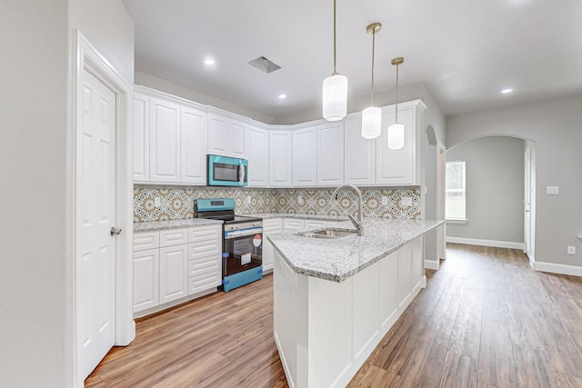 kitchen featuring sink, kitchen peninsula, stainless steel range with electric cooktop, and white cabinetry