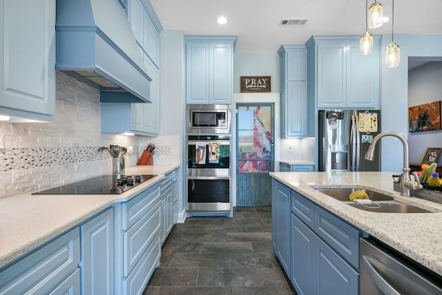 kitchen featuring stainless steel appliances, backsplash, pendant lighting, sink, and custom exhaust hood