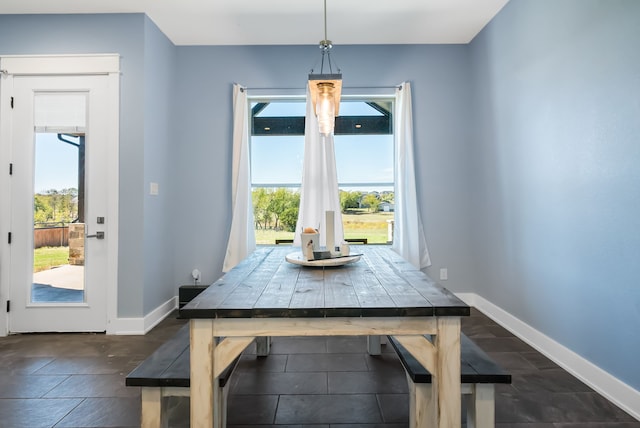 unfurnished dining area featuring dark tile floors