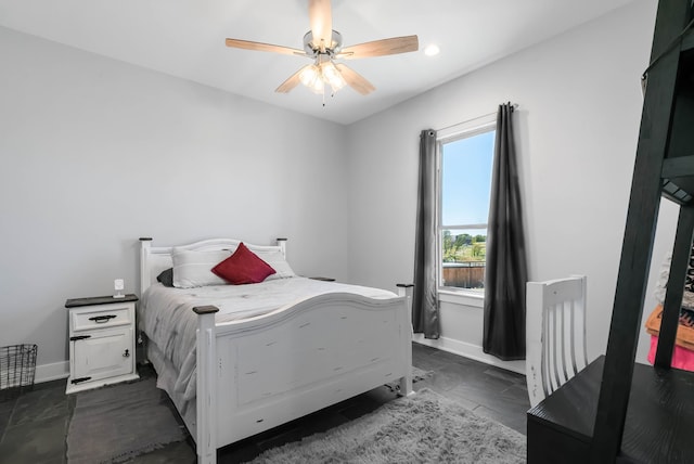 bedroom with dark tile floors and ceiling fan