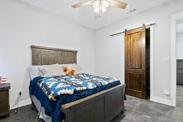 tiled bedroom with a barn door and ceiling fan