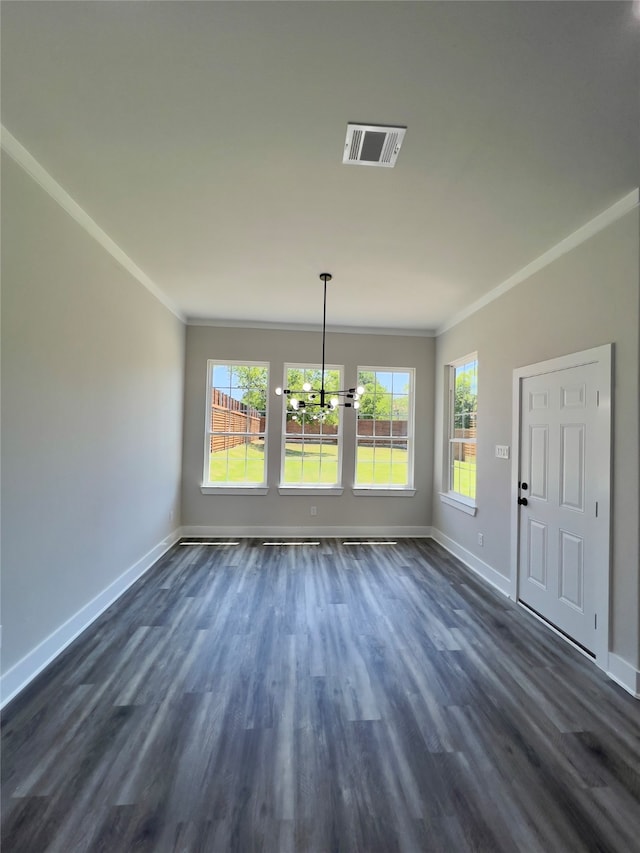 empty room with crown molding, a chandelier, and dark wood-type flooring