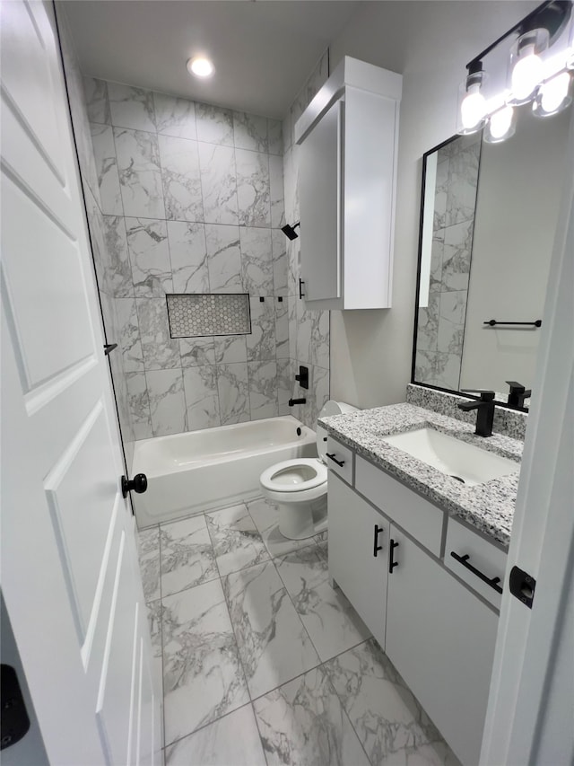 full bathroom with tile floors, tiled shower / bath combo, vanity, and toilet